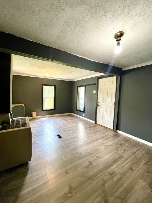 foyer featuring hardwood / wood-style floors, a textured ceiling, and beam ceiling