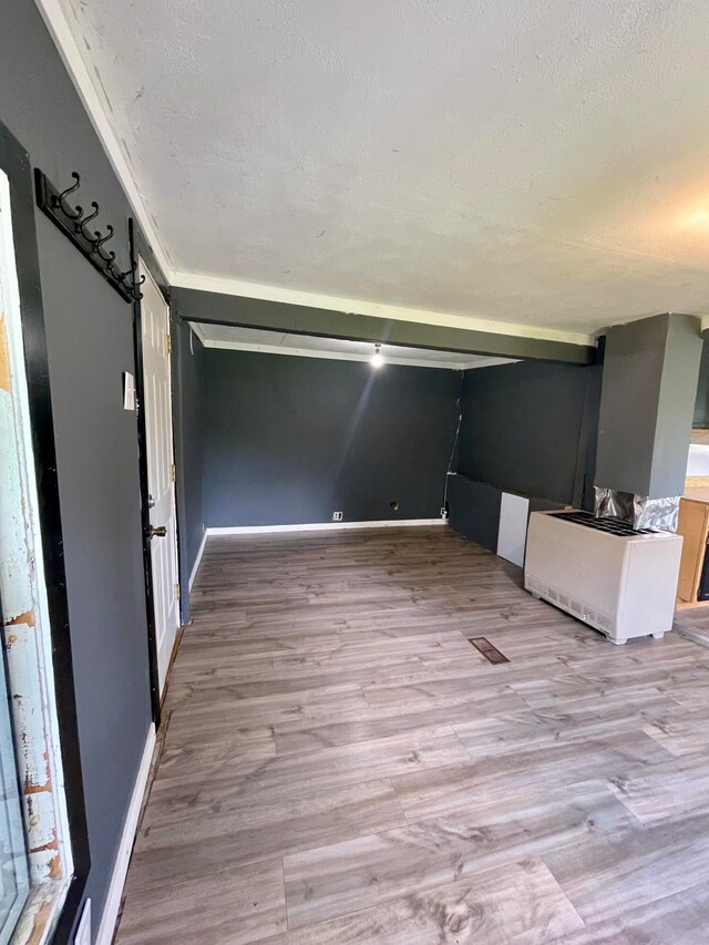 unfurnished room with a textured ceiling and light hardwood / wood-style flooring