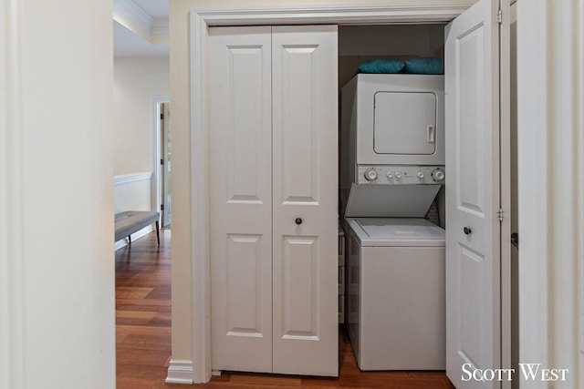 laundry area with stacked washer and dryer, laundry area, and wood finished floors