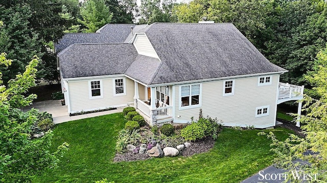 exterior space featuring roof with shingles, a yard, and a deck