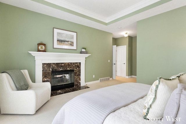 carpeted bedroom featuring crown molding and a tile fireplace