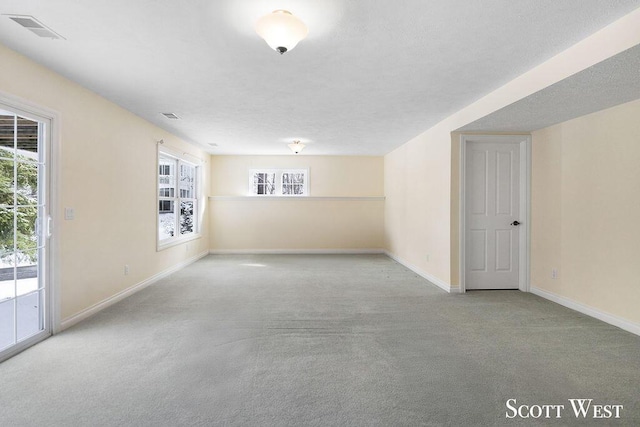 empty room with a textured ceiling and light carpet