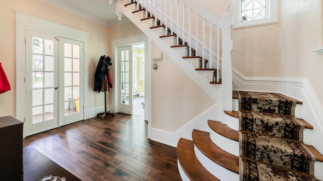 foyer with french doors, dark hardwood / wood-style floors, and ornamental molding