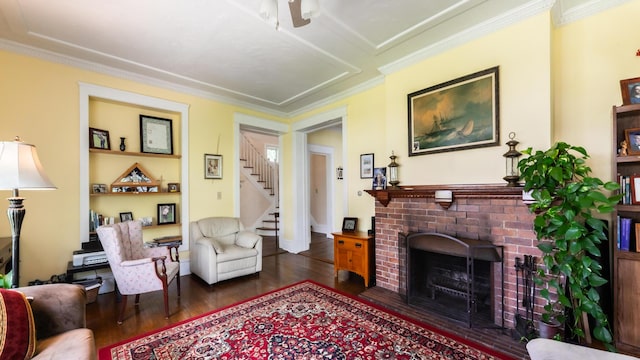 living room featuring dark hardwood / wood-style flooring, crown molding, and a fireplace