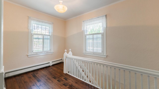 empty room featuring a baseboard heating unit, dark wood-type flooring, and ornamental molding