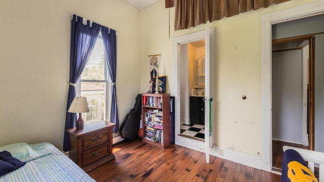 bedroom featuring a baseboard radiator, dark hardwood / wood-style floors, and a closet