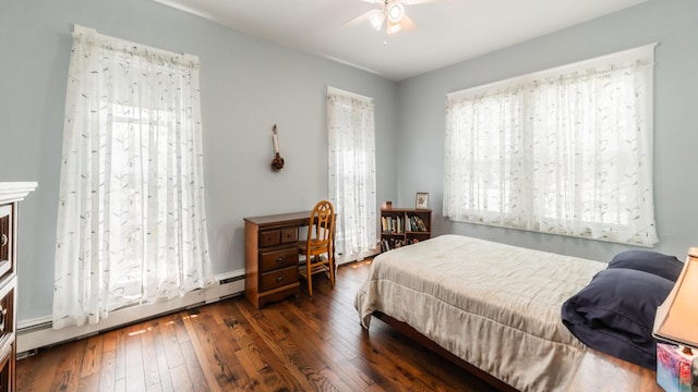 bedroom featuring a baseboard heating unit, ceiling fan, dark hardwood / wood-style floors, and multiple windows