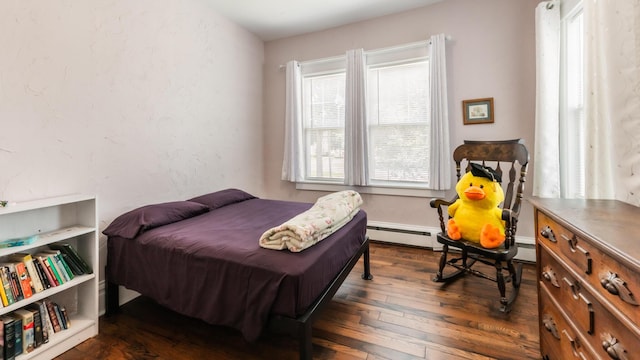 bedroom with a baseboard radiator and dark hardwood / wood-style flooring