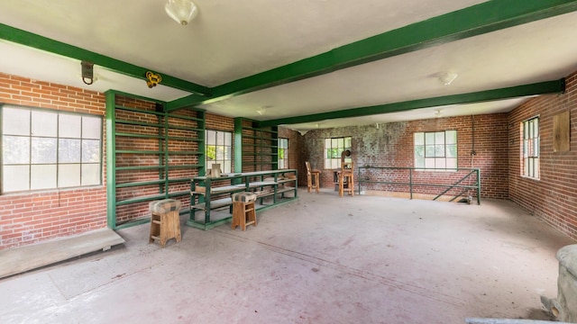 interior space with brick wall and beam ceiling