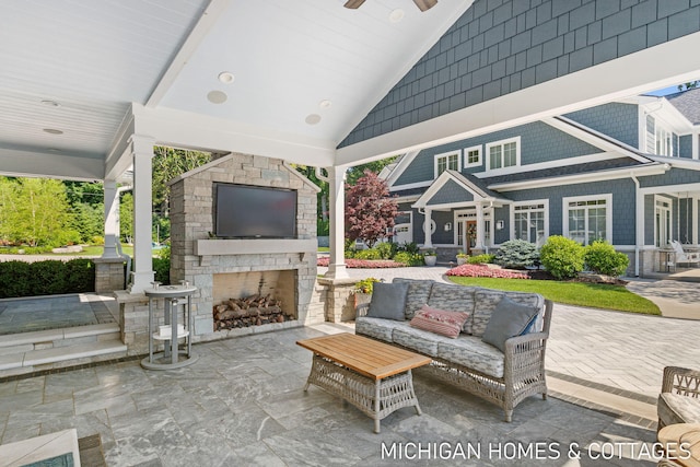 view of patio with ceiling fan and an outdoor living space with a fireplace