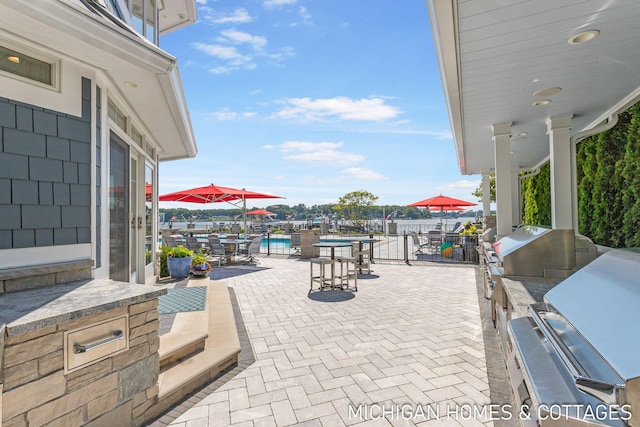 view of patio / terrace featuring a pool and an outdoor kitchen