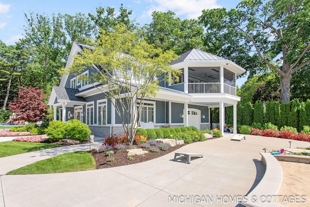 view of front of house with a garage, a balcony, ceiling fan, and a sunroom