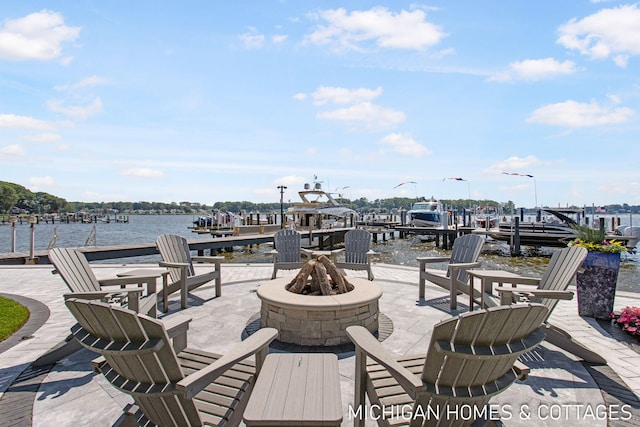 view of patio / terrace featuring a water view, a dock, and a fire pit