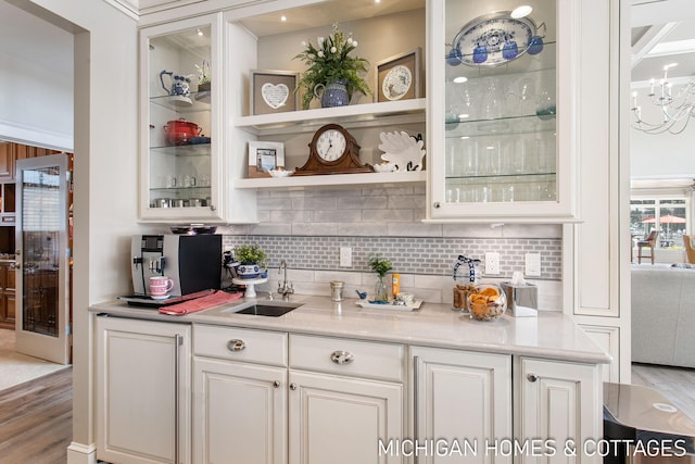 bar with white cabinets, sink, stainless steel fridge, and backsplash