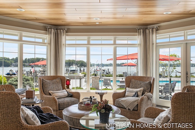 sunroom / solarium featuring a water view, a wealth of natural light, and wood ceiling