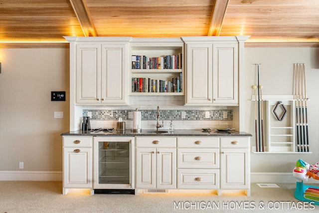 bar with wine cooler, sink, wooden ceiling, decorative backsplash, and white cabinets