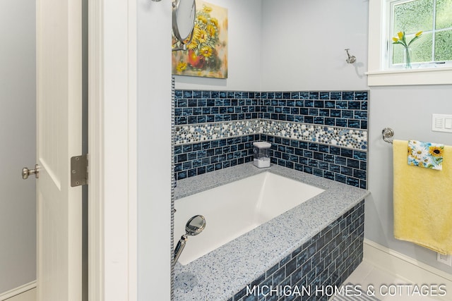 bathroom featuring tile patterned floors and a tub