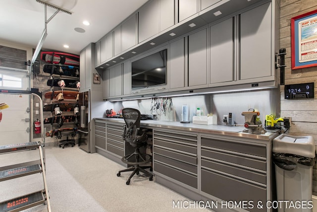 carpeted office space featuring wooden walls