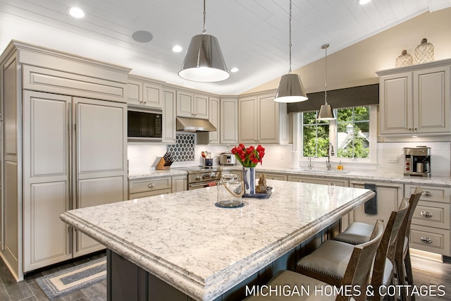 kitchen with built in appliances, wood ceiling, vaulted ceiling, and a kitchen island