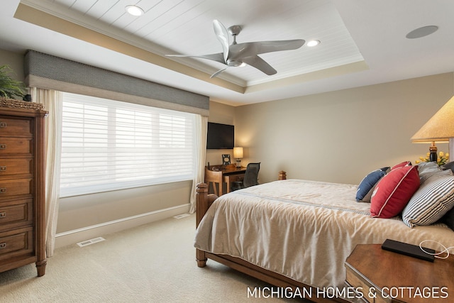 carpeted bedroom featuring a raised ceiling, ceiling fan, and multiple windows