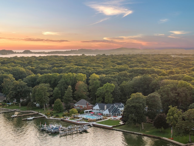 aerial view at dusk featuring a water view