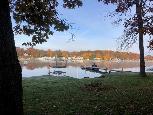 dock area with a lawn and a water view