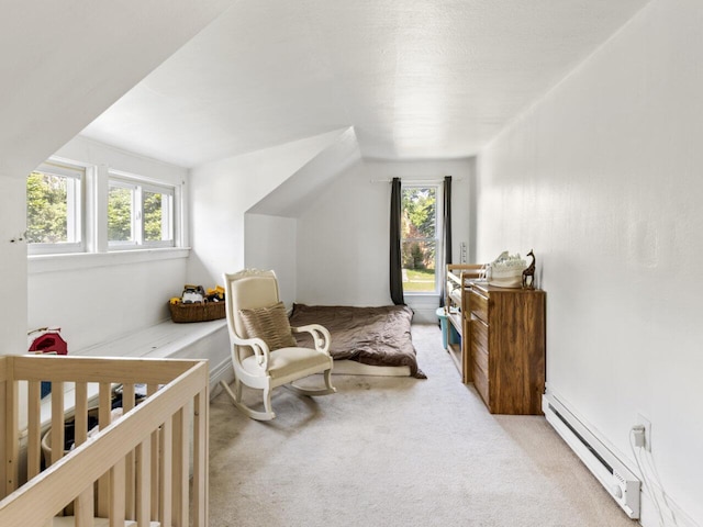 carpeted bedroom featuring a baseboard heating unit and a crib