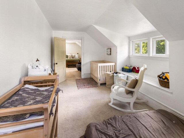 carpeted bedroom featuring a nursery area