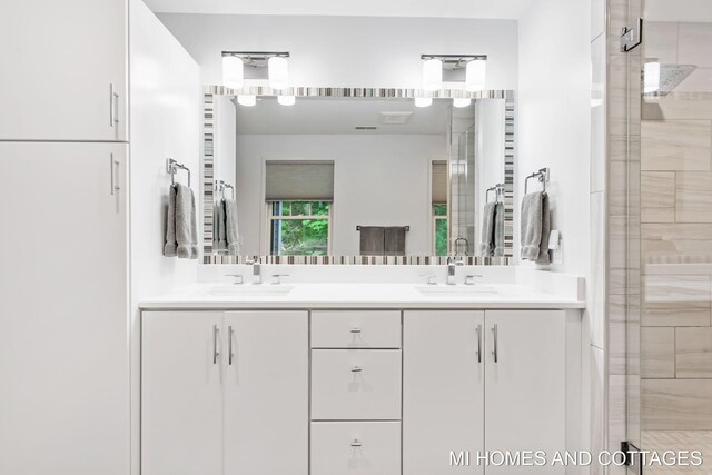 bathroom with double vanity and an enclosed shower