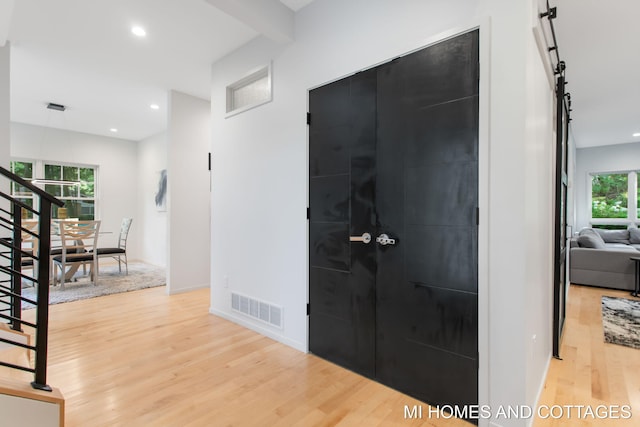 entrance foyer featuring light hardwood / wood-style floors, a barn door, and a wealth of natural light