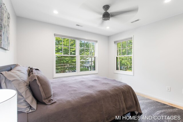 bedroom featuring multiple windows, ceiling fan, and hardwood / wood-style floors