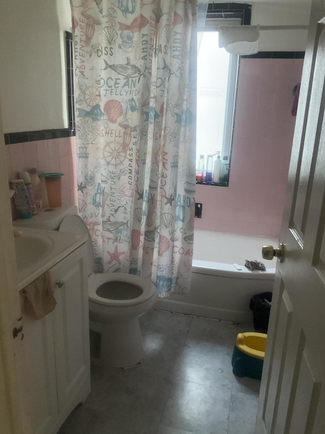 full bathroom featuring shower / bath combination with curtain, vanity, toilet, and tile walls