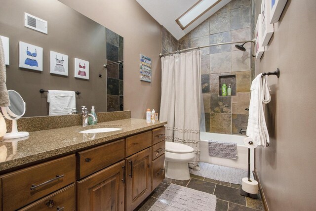 full bathroom with toilet, tile patterned flooring, shower / bath combo with shower curtain, vanity, and lofted ceiling with skylight