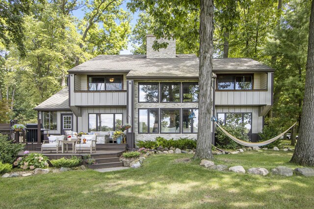 back of house featuring a wooden deck, an outdoor hangout area, and a yard