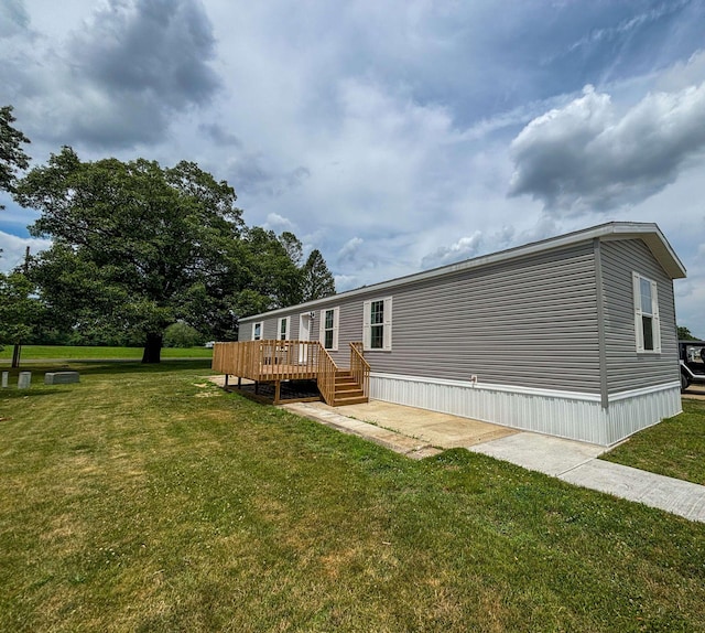 back of property with a wooden deck and a yard