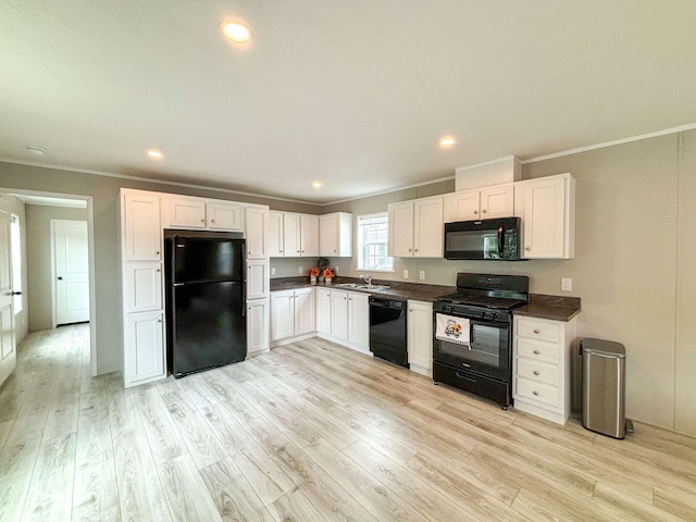 kitchen featuring sink, light hardwood / wood-style flooring, black appliances, and white cabinets