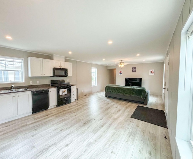 kitchen featuring sink, ceiling fan, black appliances, light hardwood / wood-style floors, and white cabinets