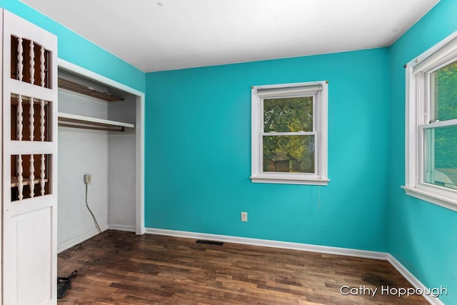 unfurnished bedroom featuring dark wood-type flooring and a closet