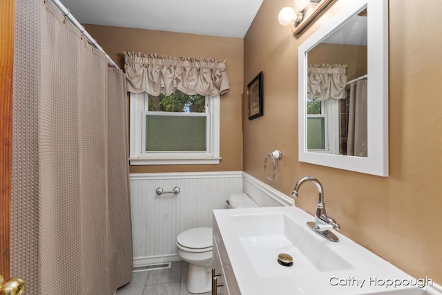 bathroom featuring tile patterned flooring, vanity, and toilet