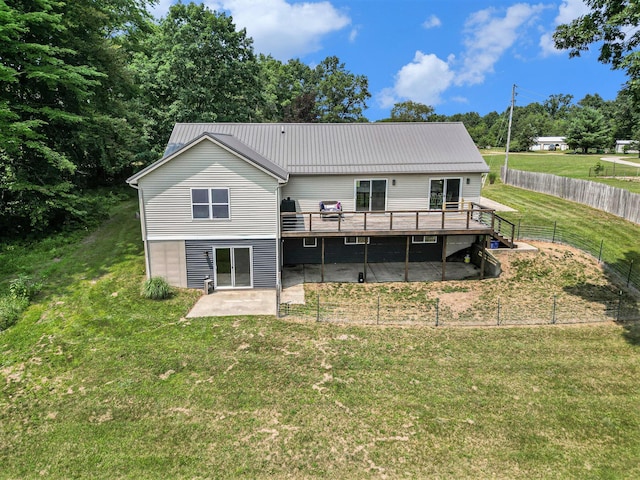 rear view of property with a wooden deck, a yard, and a patio area