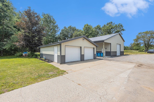 view of front of house featuring a garage, an outdoor structure, and a front yard