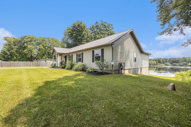 view of side of property featuring a water view and a lawn