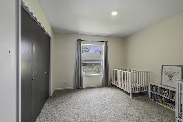 bedroom with a crib, a closet, and carpet