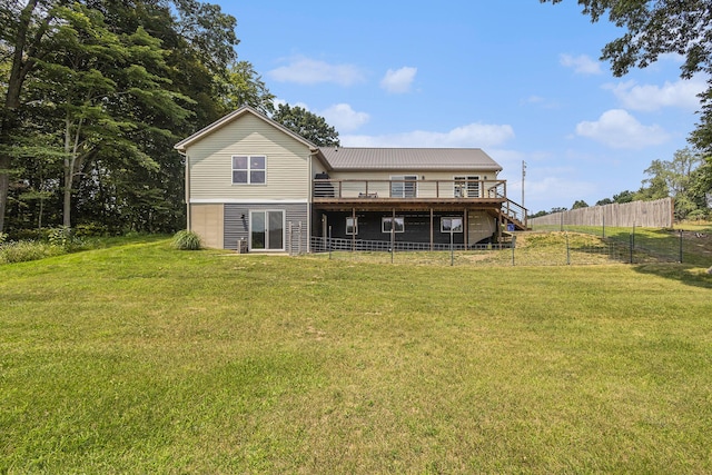 back of house featuring a wooden deck and a yard