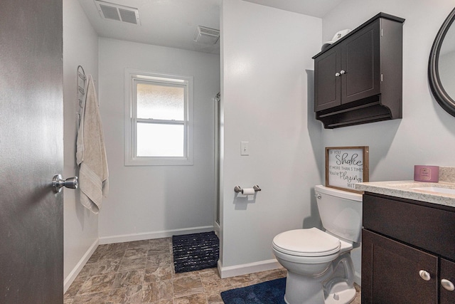 bathroom featuring vanity, toilet, and walk in shower