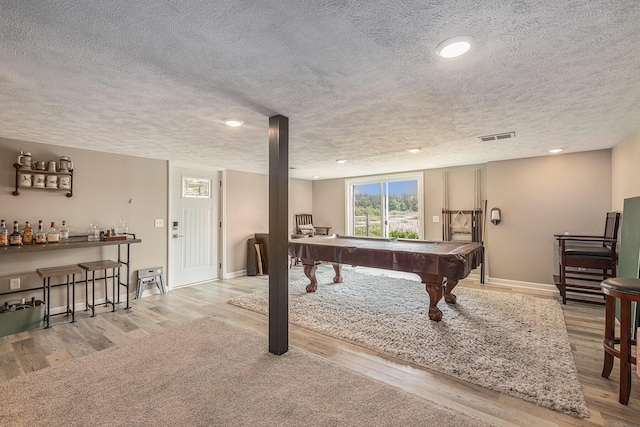 playroom with pool table, a textured ceiling, and light wood-type flooring