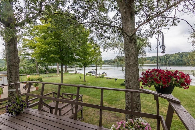 wooden deck featuring a water view and a yard