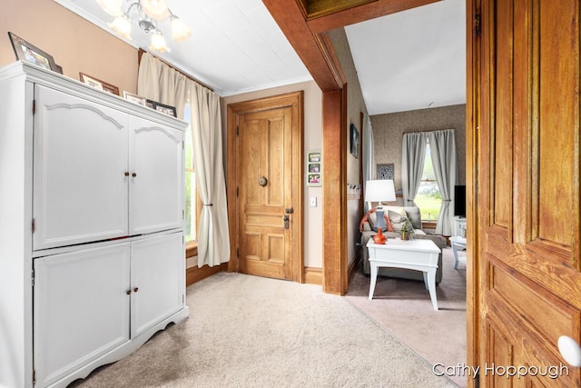 carpeted foyer featuring ornamental molding