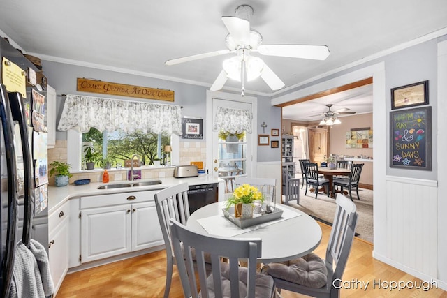 dining space with light hardwood / wood-style flooring, sink, crown molding, and a wealth of natural light