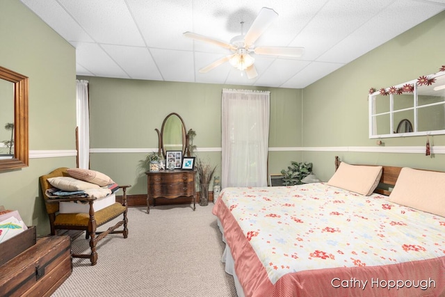 carpeted bedroom with ceiling fan and a paneled ceiling